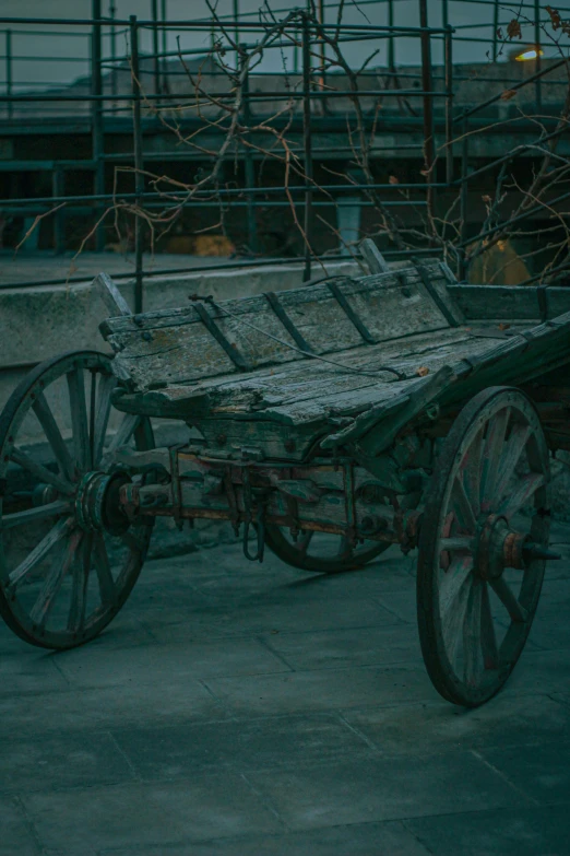 a cart with rusted wheels and a wooden plank top