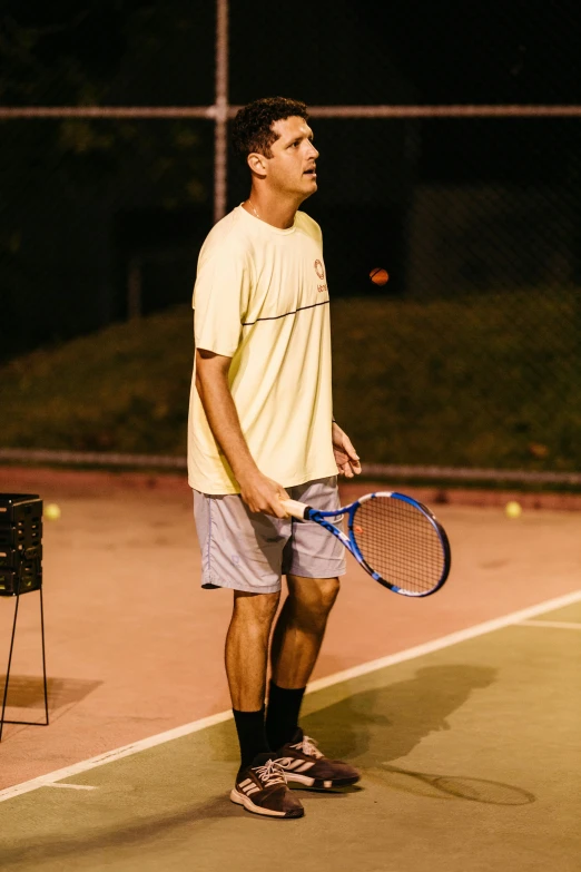 there is a male tennis player wearing shorts and a yellow shirt