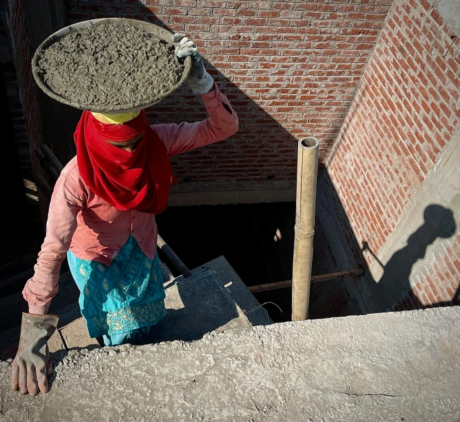 a woman carrying a large piece of rock over her head