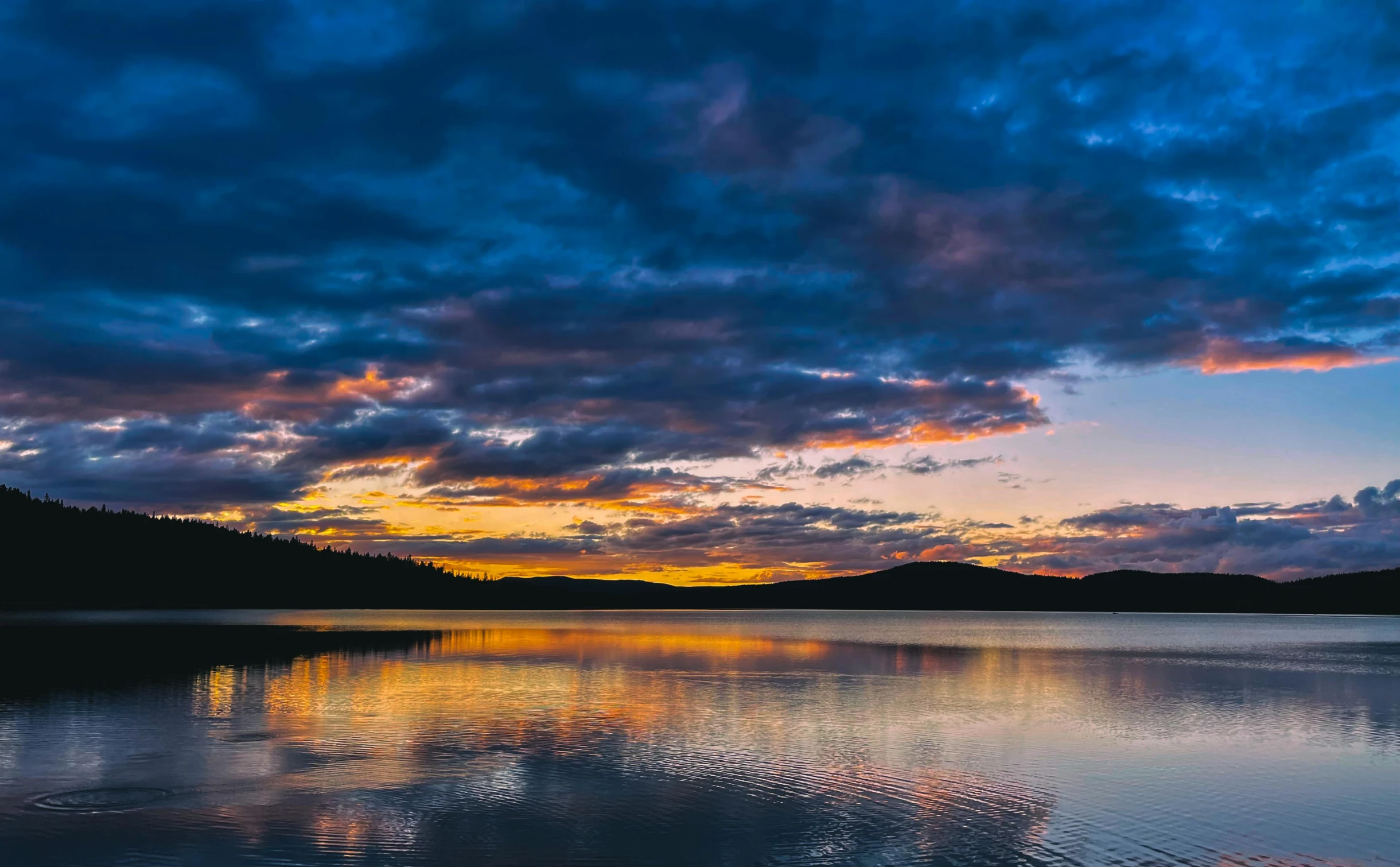 sunset at a lake with mountains in the background