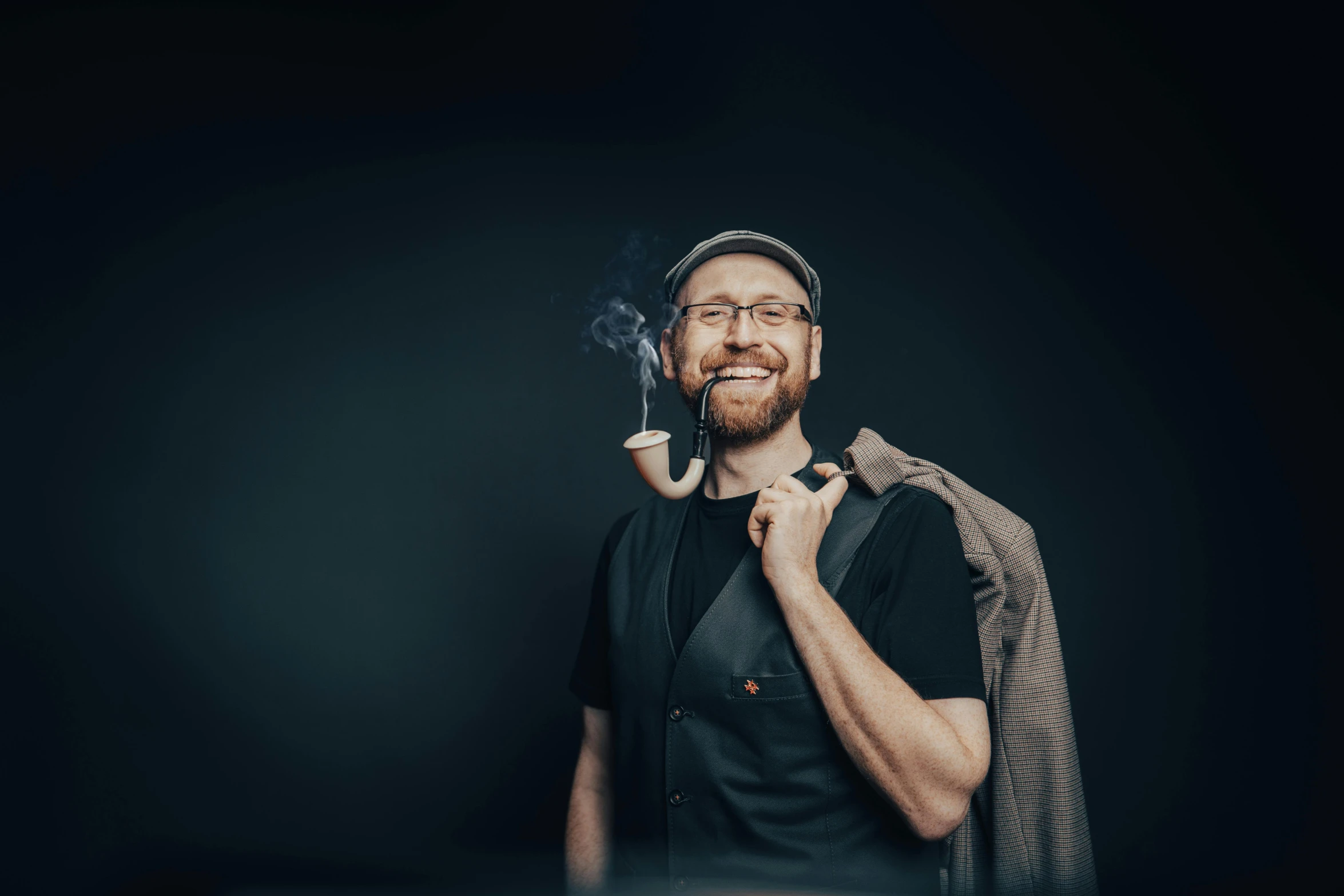 man smoking a pipe and smiling in the dark