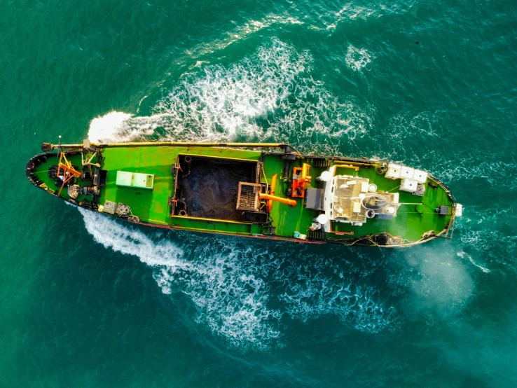 an image of a green boat in the middle of water