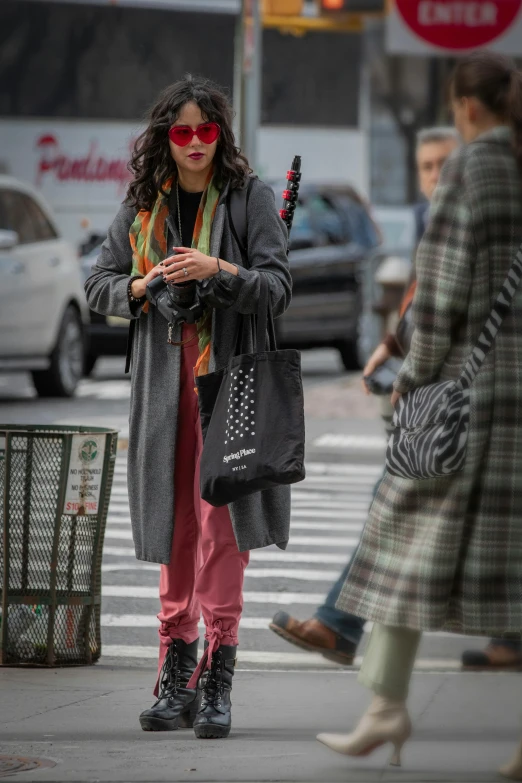 the woman in the plaid jacket is standing by the street