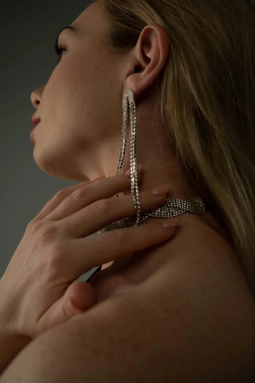 a woman with large gold jewelry is posing