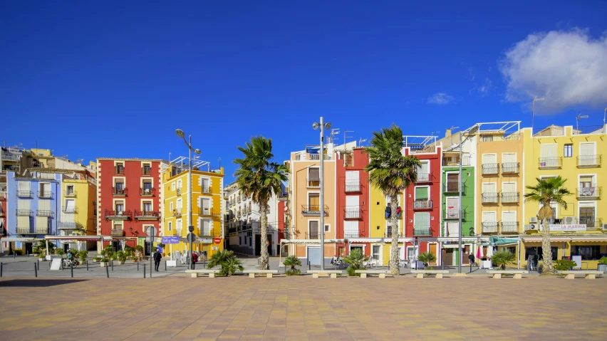 a row of multi colored apartment buildings with palm trees