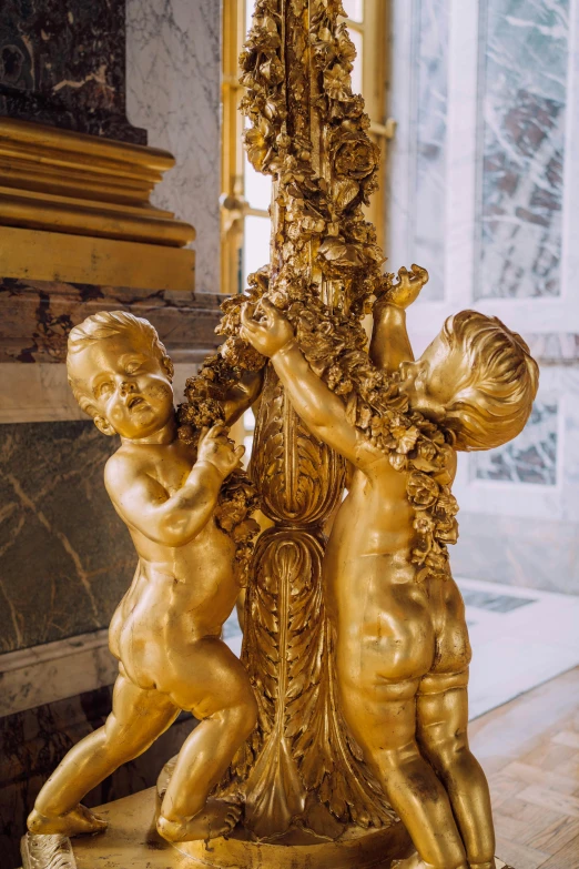 a gold statue with two children on top of it