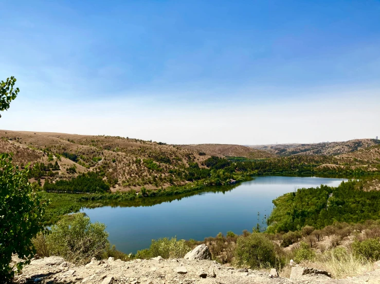 a large lake in a dry area with trees around it