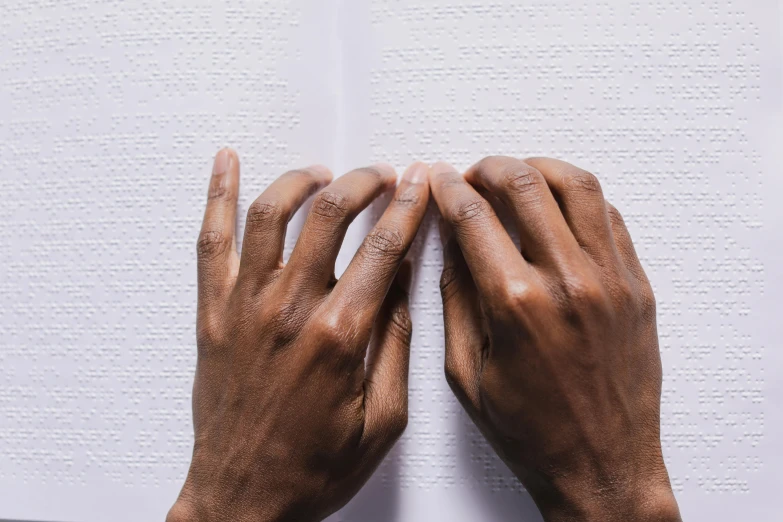 hands with their fingers on a book