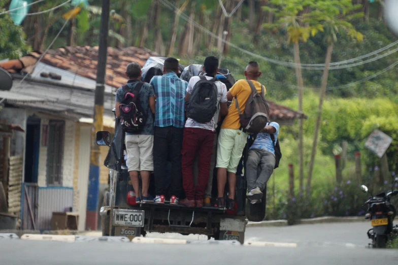 group of people standing in the back of a pick up truck