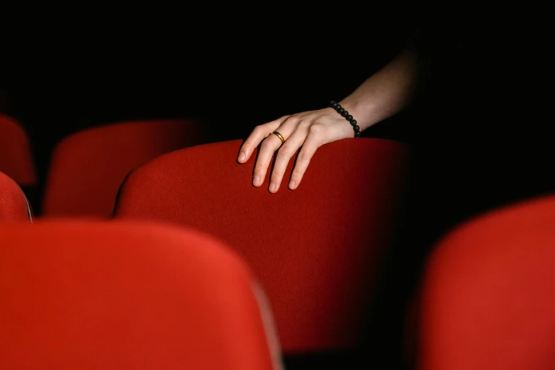 a closeup of a hand resting on the seat of a chair