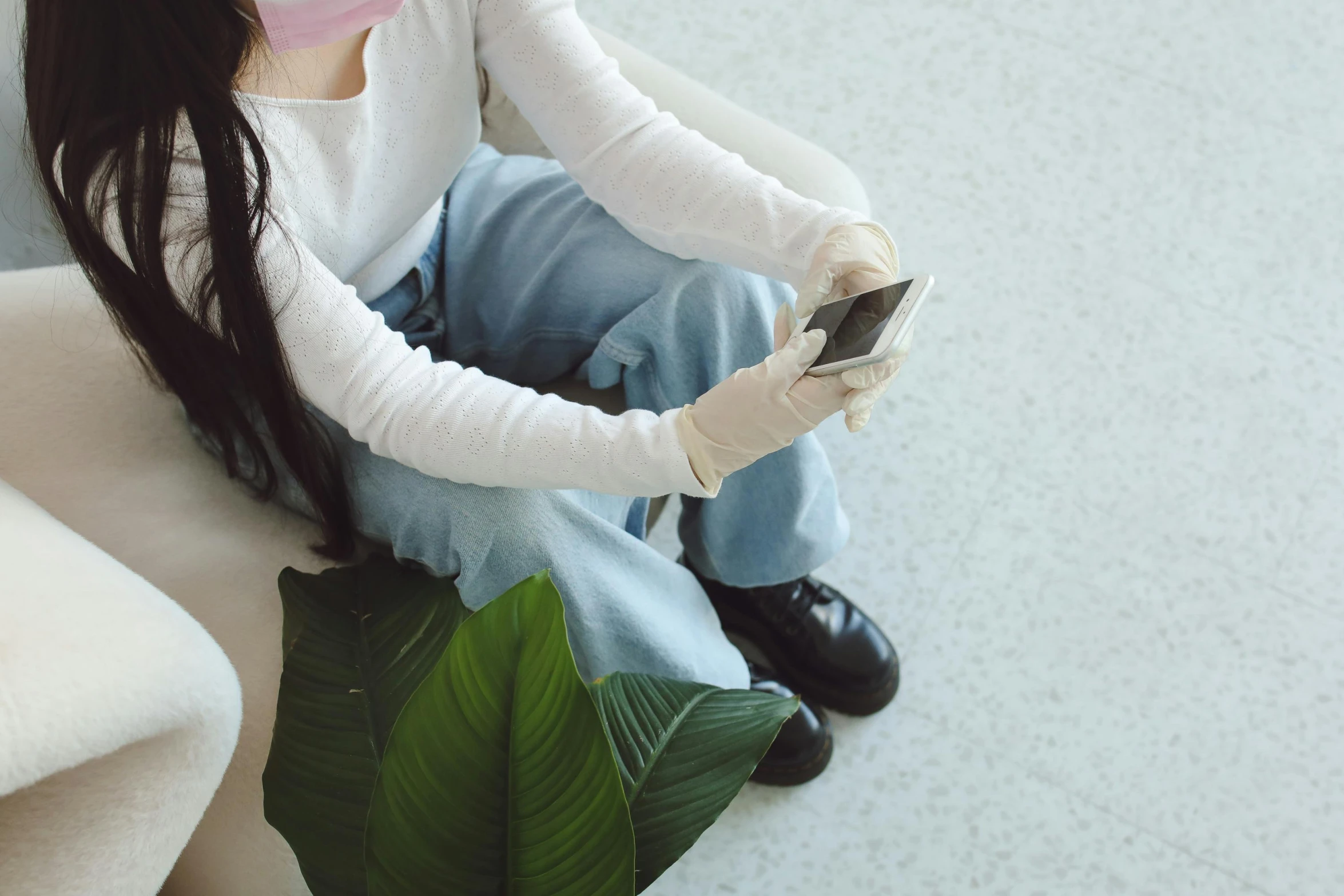 a girl sitting on a couch with a cat in her hand