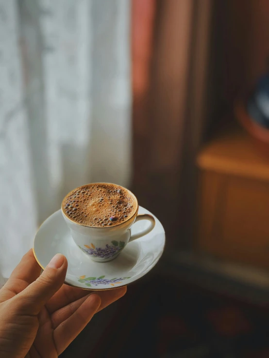 a person holding a coffee cup filled with water