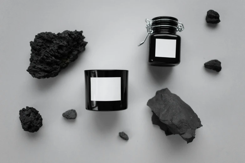 a candle with labels is surrounded by rocks