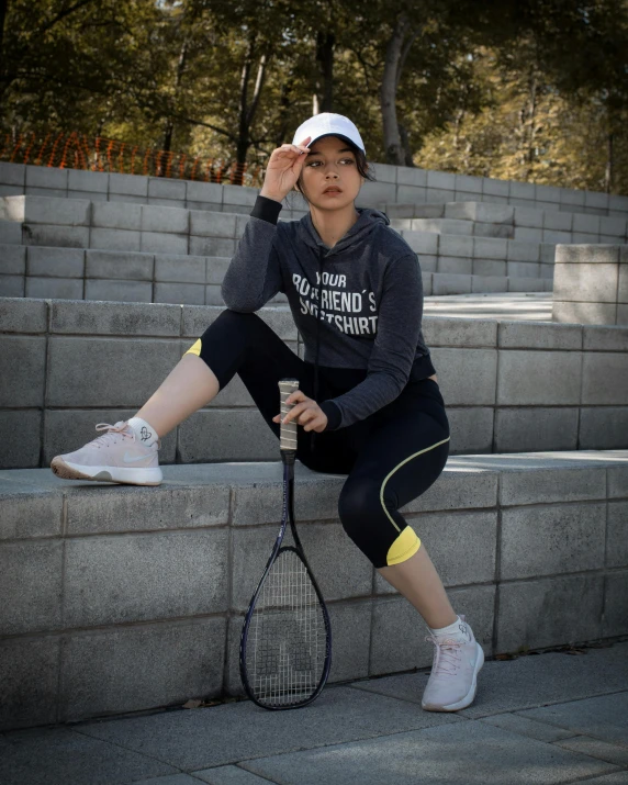 a person that is sitting on some steps with a racket
