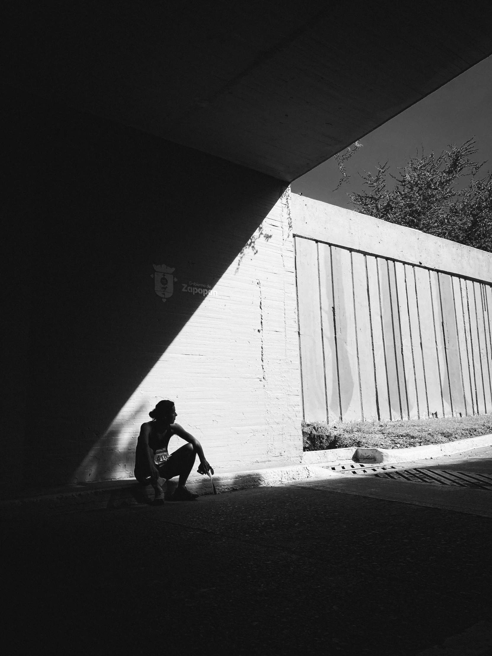 a person sitting in the dark with a skateboard