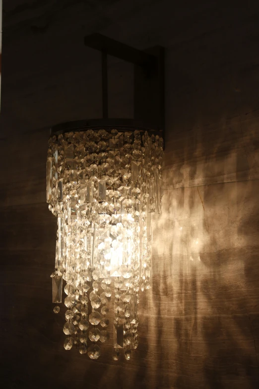 a small clear glass chandelier hanging from the wall