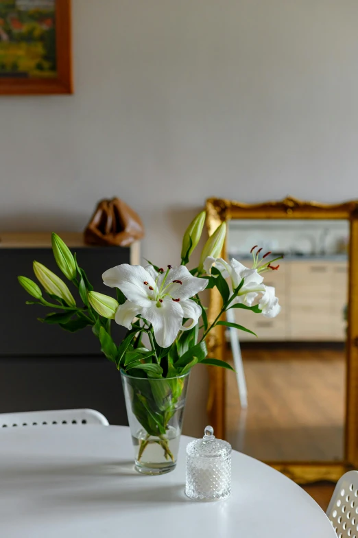 white flowers in a vase sitting on top of a table