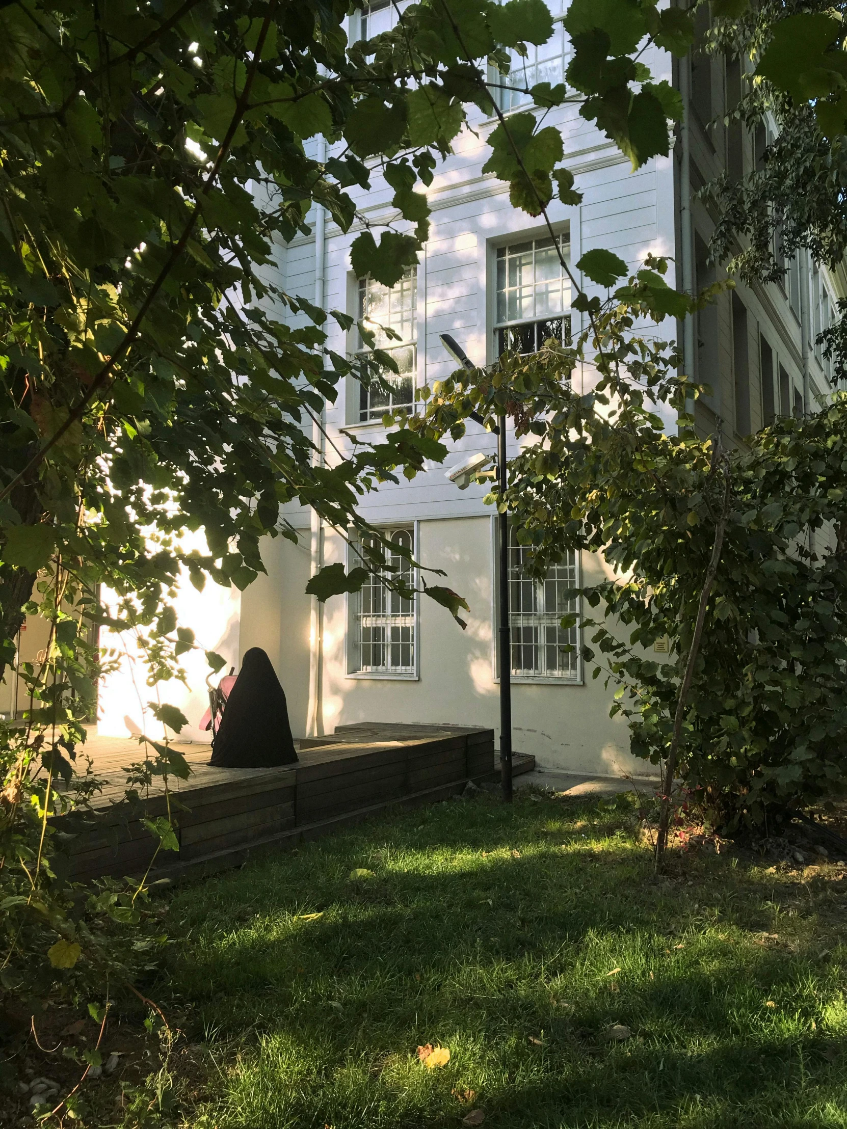 a white building that is sitting next to trees