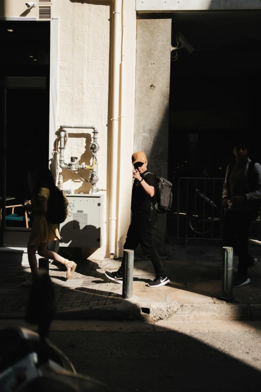 a person is talking on his cell phone while standing by a building