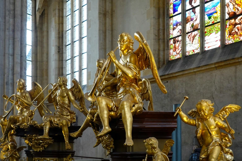 gold colored statues of cherubs are displayed in the cathedral