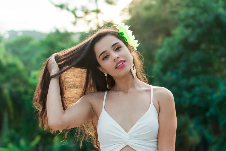 a woman holding her hair in a bikini and a white towel with flowers