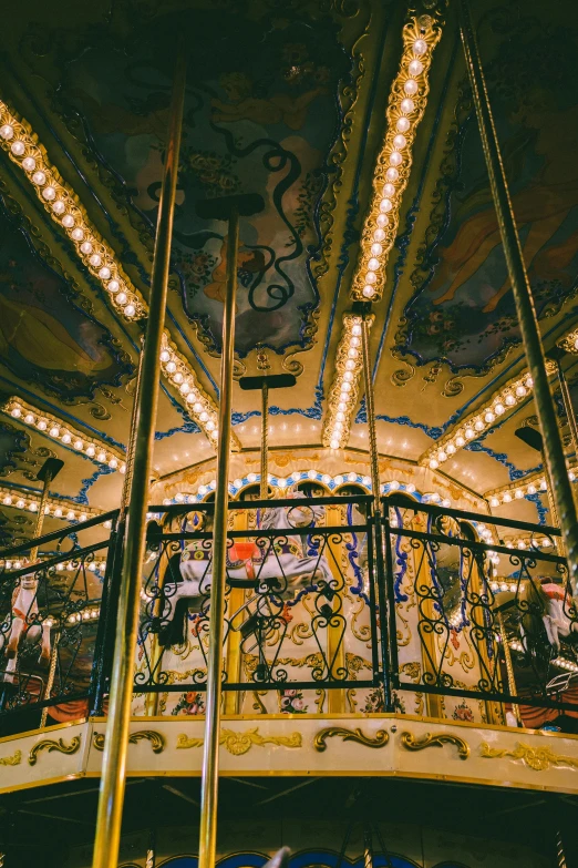 a colorful, lit carousel has multiple lights and mirrors