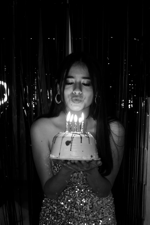 a woman holds a cake with candles on it