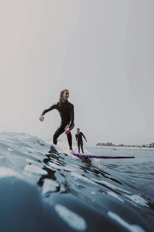 two people on surfboards riding together on the water