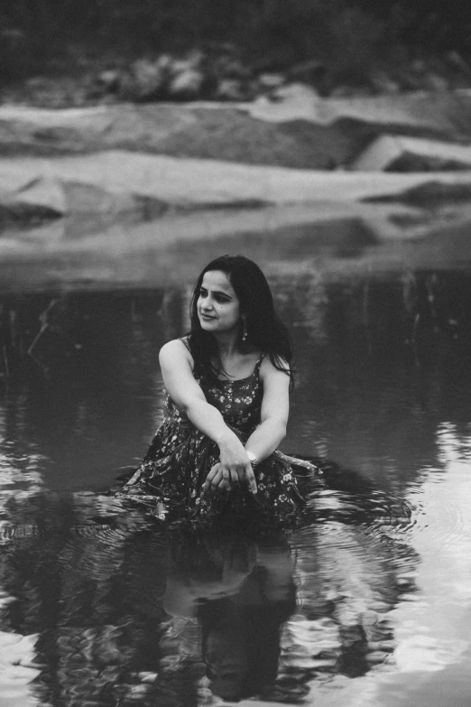 a woman is sitting in the water looking back