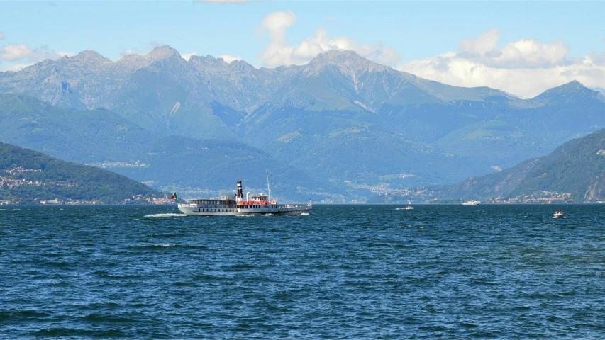a large boat on the ocean near mountains
