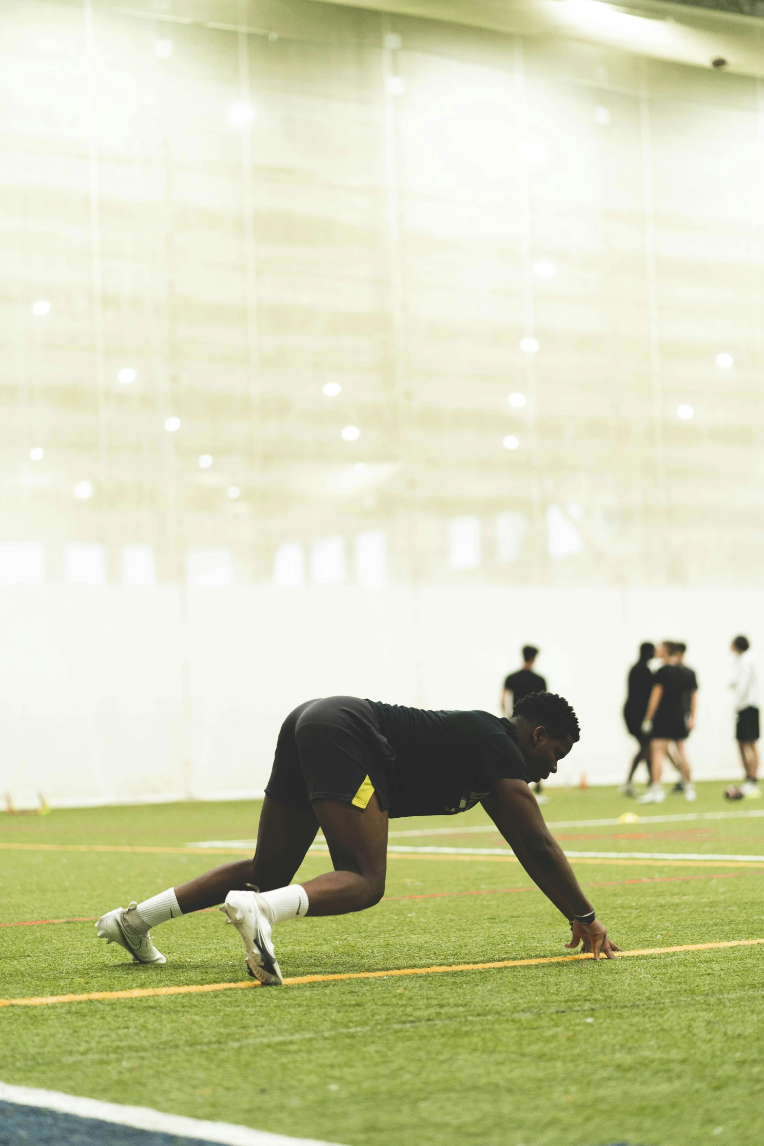 a person in black shirt doing exercises on grass