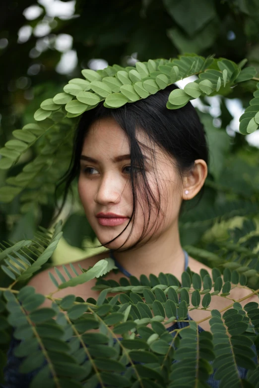 a young asian woman with leaves over her head