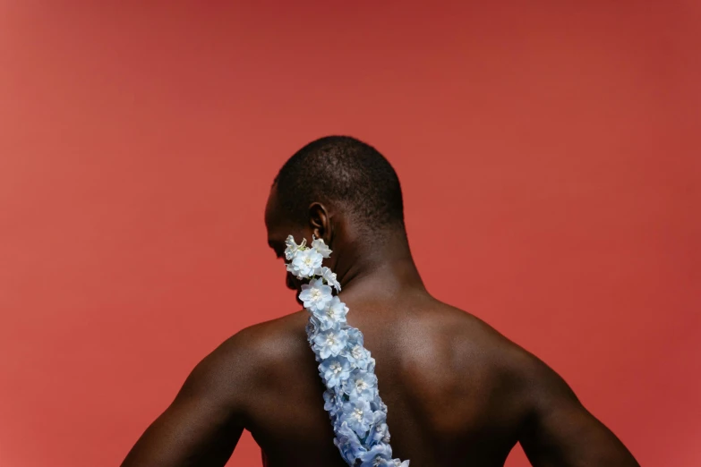 a man with a flowered tie behind his back