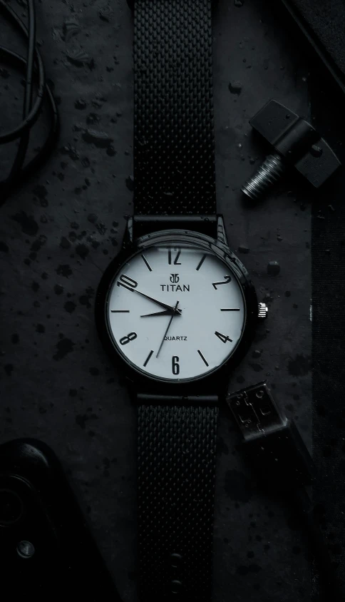 a wrist watch sits on the floor with tools surrounding it