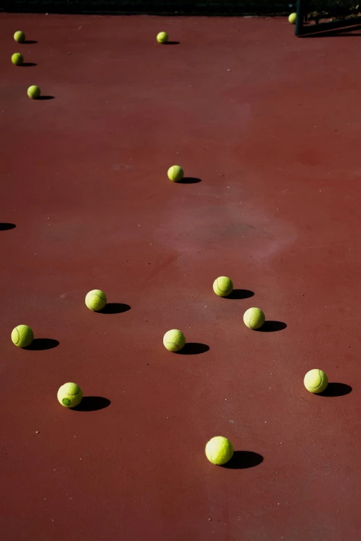 many tennis balls laying on the ground