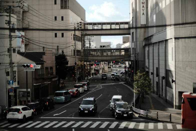 a city street filled with traffic and cars near a bridge