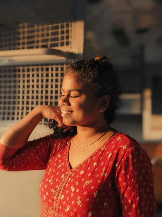 a young woman smiles while leaning against a wall