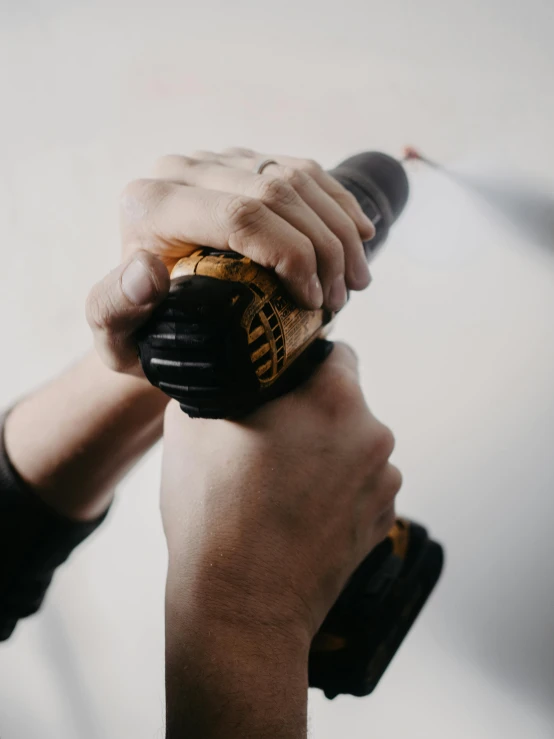 a person's hand holding onto a black object with a red light on it