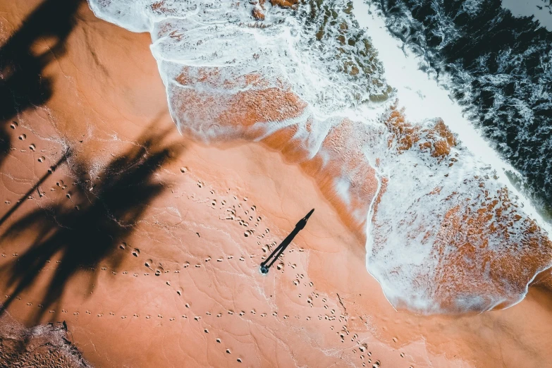 a beach with an ocean wave coming in to shore