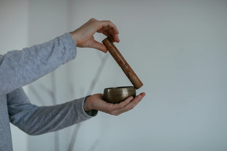 a woman is holding a small brown bowl