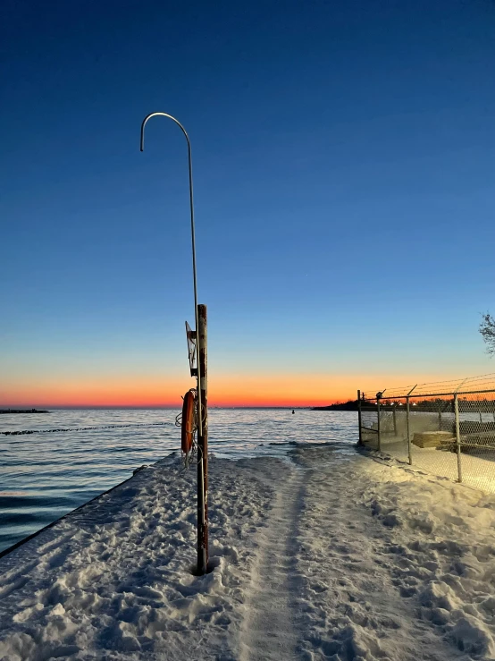 a fishing pole next to a small pole on top of snow