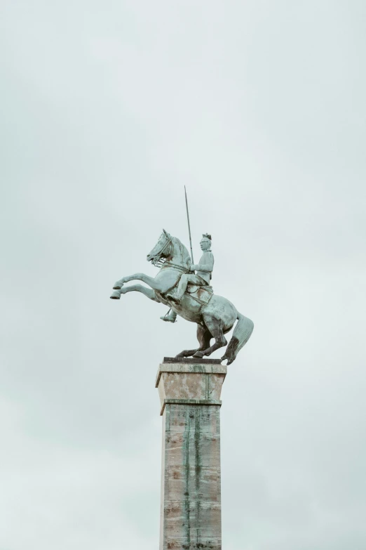 a statue of a horse mounted on top of a brick wall