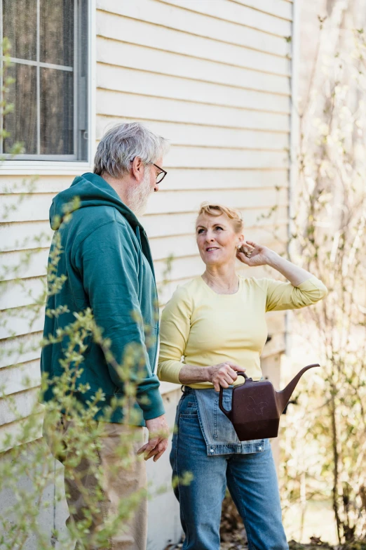 the man and woman are standing in front of the house