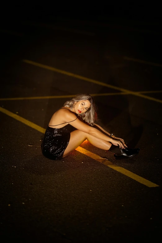 a woman in short dress sitting on the side of a road