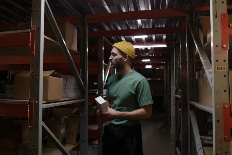 man with a note card in his hand while holding a package