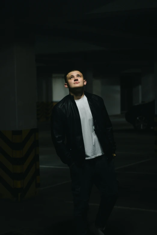 a young man standing in an empty parking garage