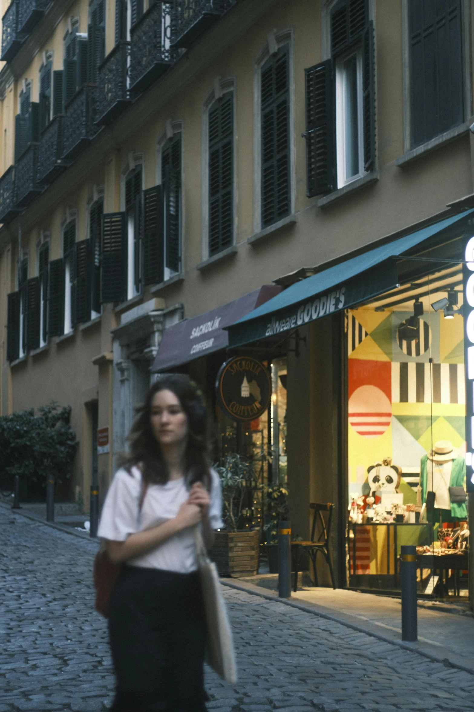 a woman walking past an apartment building on the street