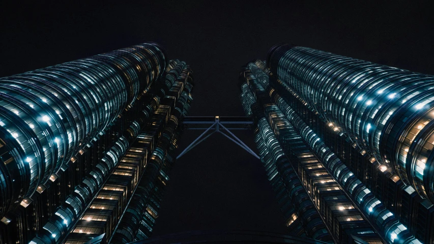 two large tall buildings illuminated at night