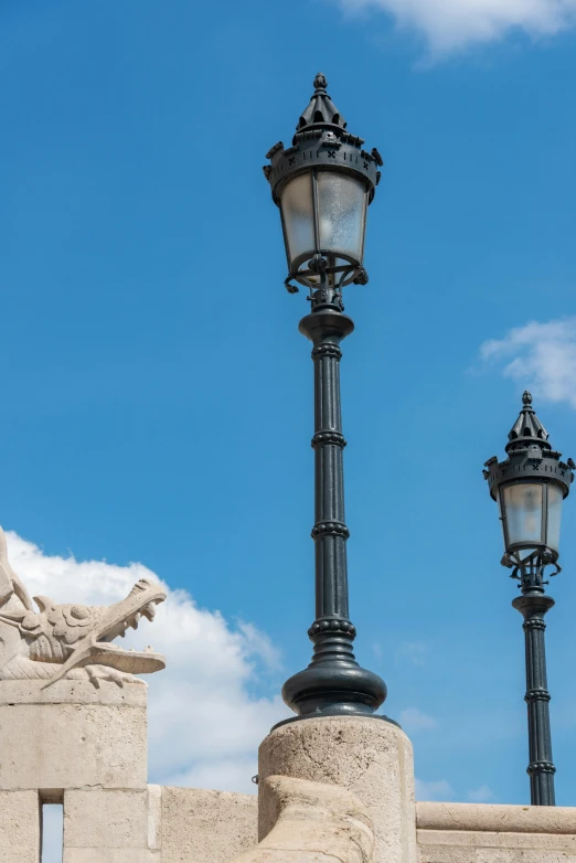 a black lamp and stone statue on a clear day