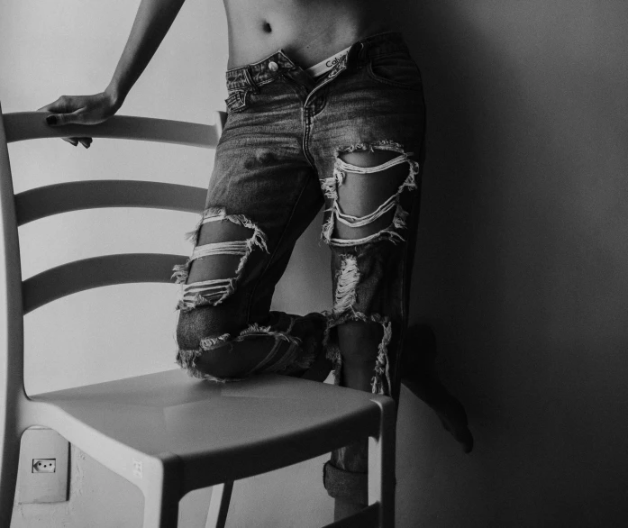 a shirtless male is leaning against the side of a chair